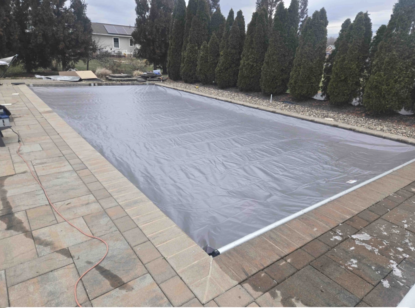 Automatic pool cover deployed over a residential pool